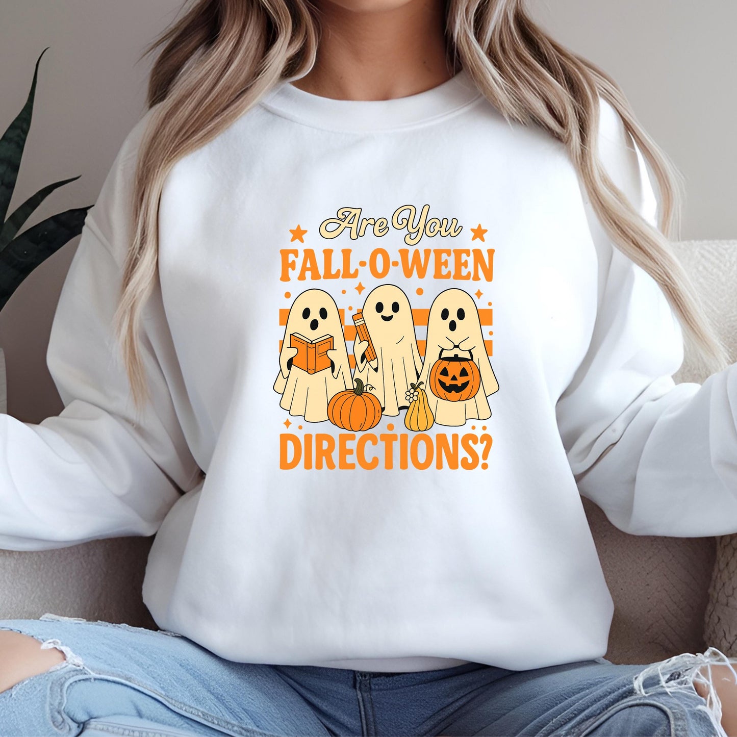 A white sweatshirt with a graphic design featuring three ghostly figures and text that reads "Are You FALL-O-WEEN DIRECTIONS?".