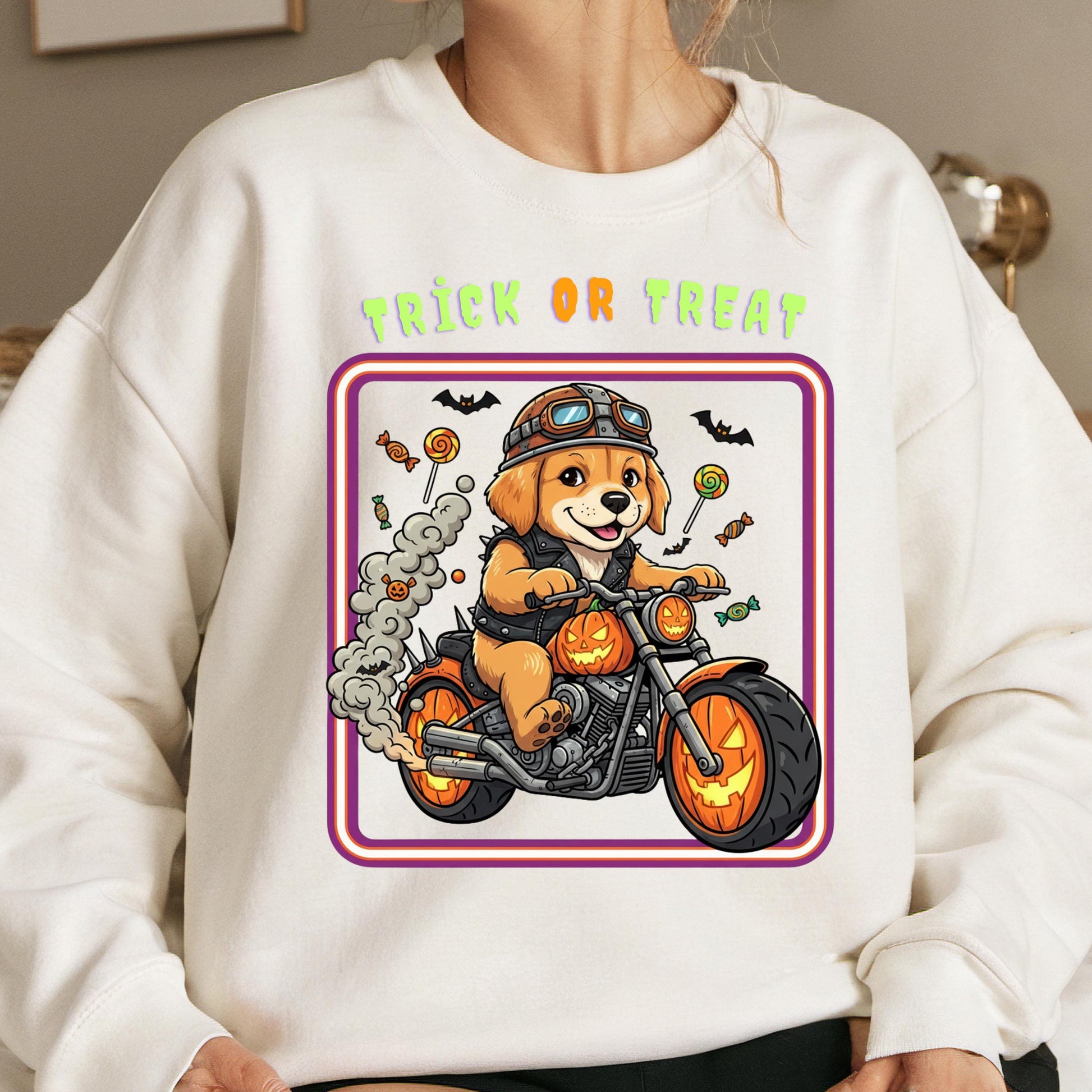 A white sweatshirt with a graphic design depicting a cartoon dog riding a motorcycle, surrounded by Halloween-themed elements such as bats, candy canes, and pumpkins.