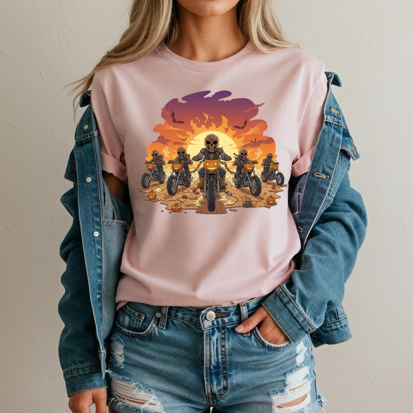 A woman wearing a pink t-shirt with a graphic design of a group of people riding motorcycles against a sunset background.
