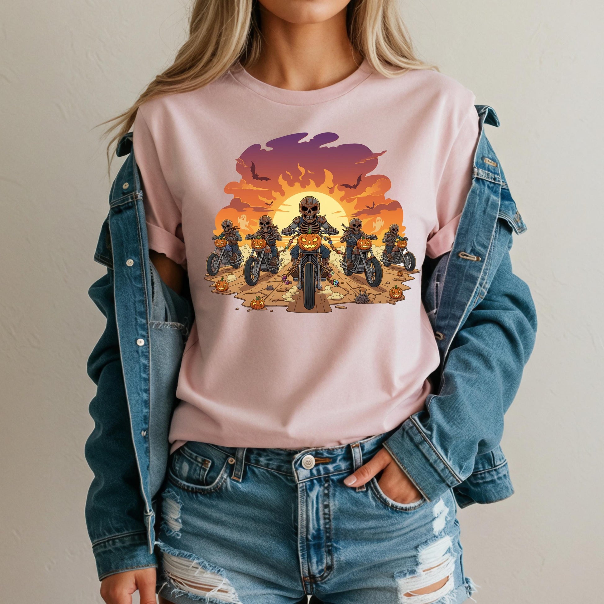 A woman wearing a pink t-shirt with a graphic design of a group of people riding motorcycles against a sunset background.