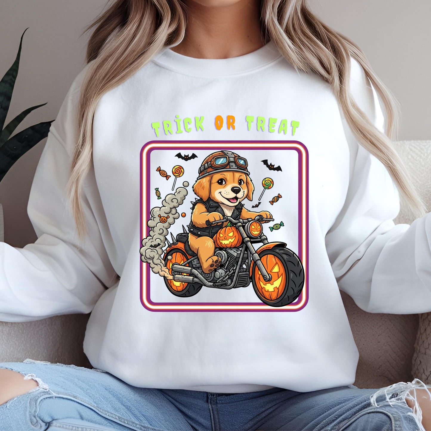 A white sweatshirt with a graphic design depicting a dog riding a motorcycle, surrounded by Halloween-themed elements such as bats, candy canes, and pumpkins.