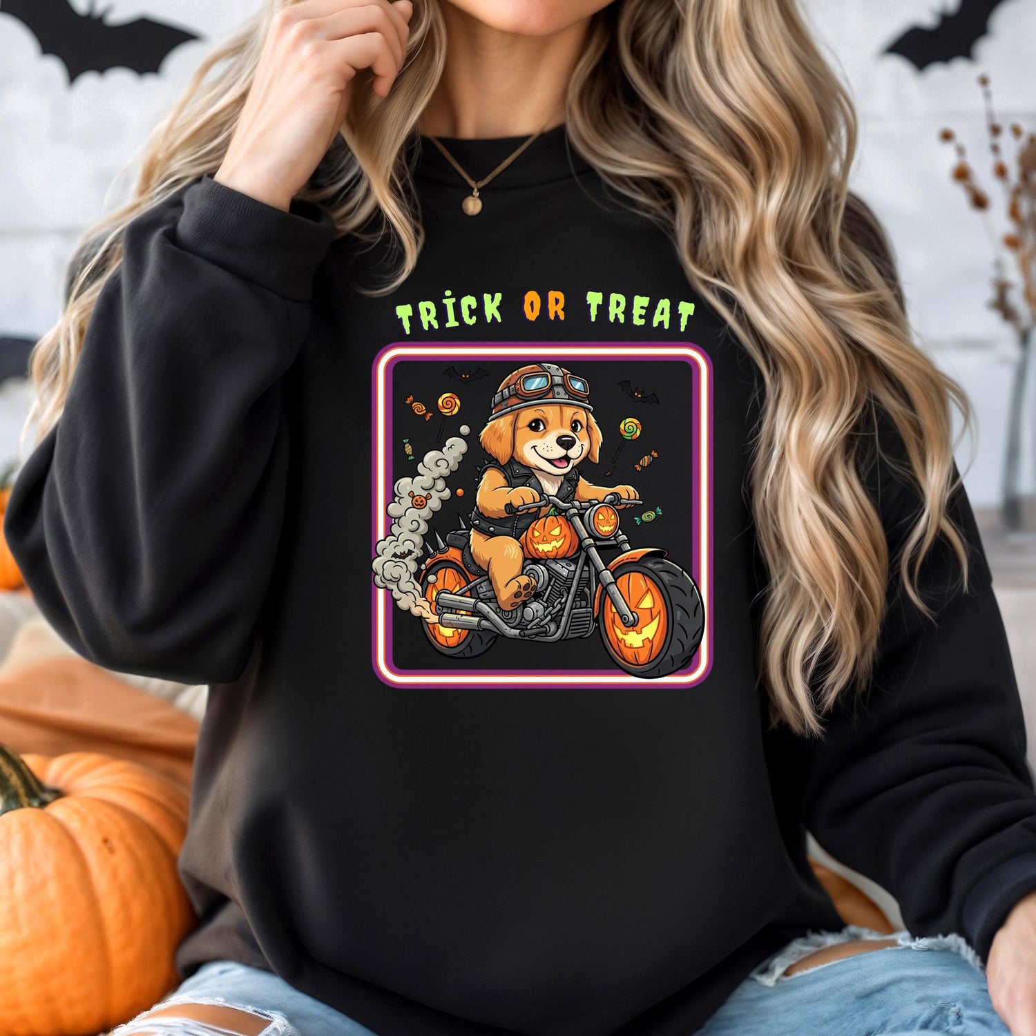A woman wearing a black sweatshirt with a graphic of a dog riding a motorcycle and the text "TRICK OR TREAT" printed on it.