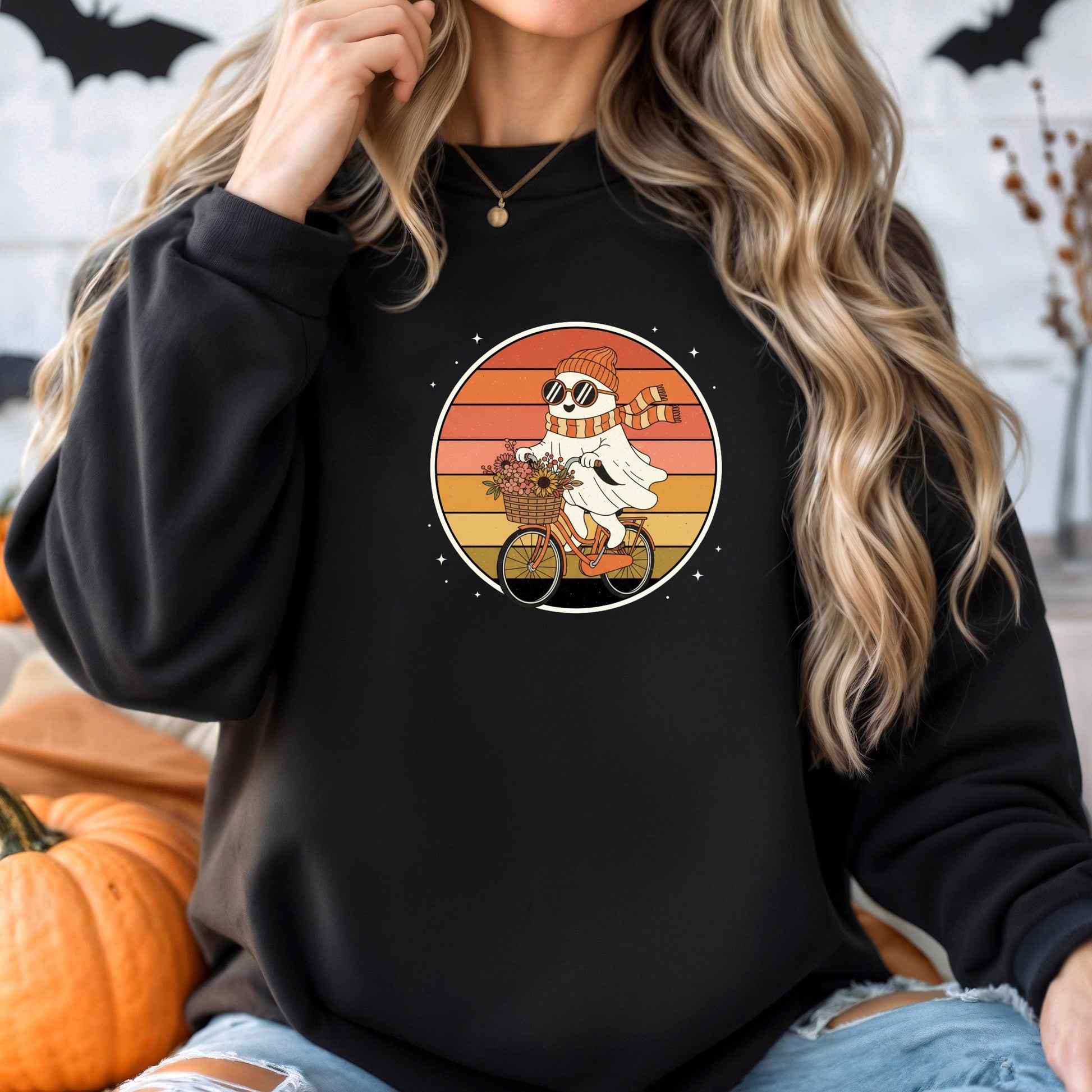 A woman wearing a black sweatshirt with a graphic of a ghost riding a bicycle.