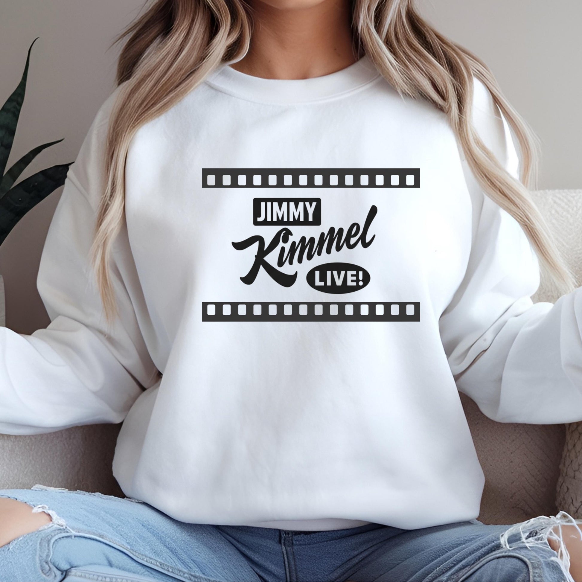 A woman wearing a white sweatshirt with the text &quot;JIMMY KIMMEL LIVE!&quot; printed on it.