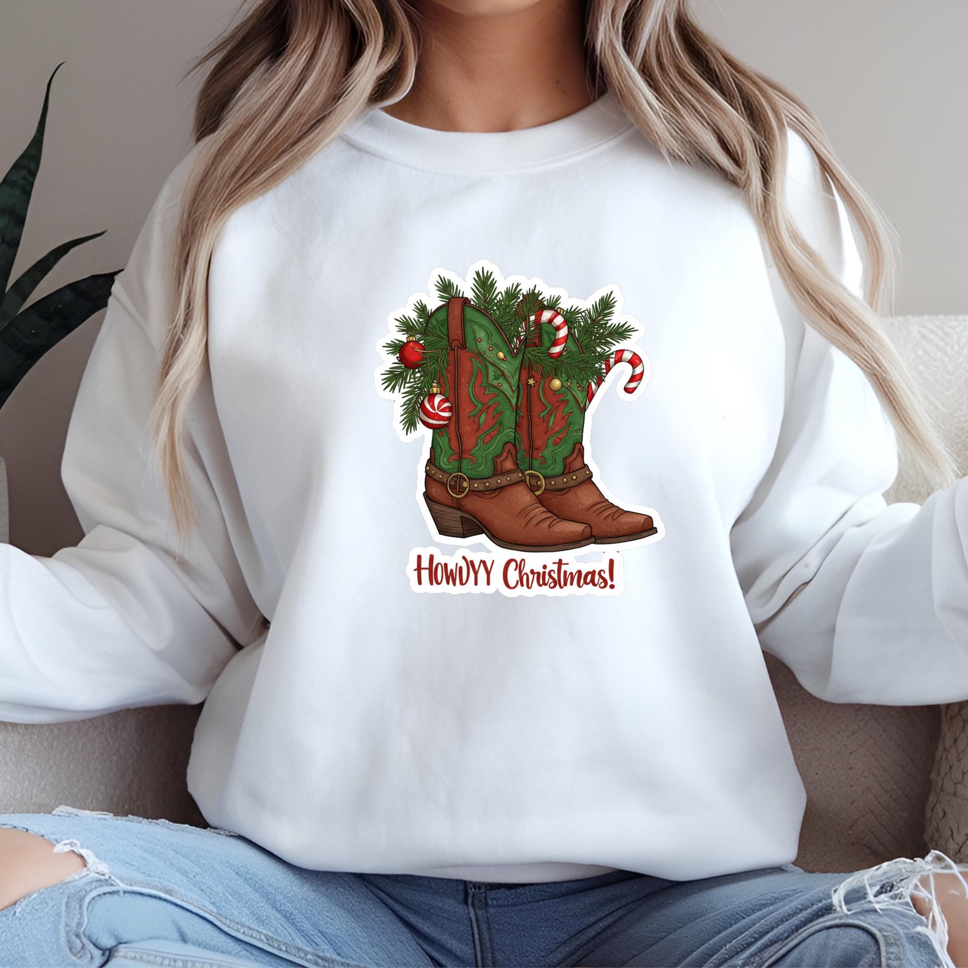 A woman wearing a white sweatshirt with a graphic of a Christmas boot on it.