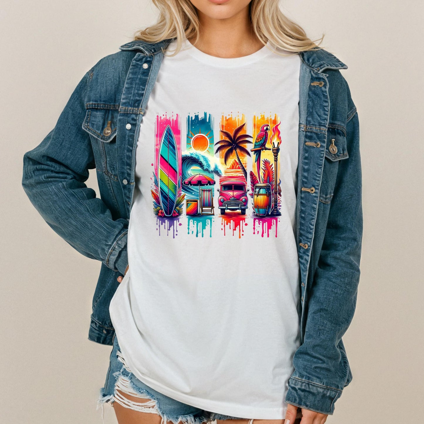 A woman wearing a denim jacket and a white t-shirt with a colorful graphic design featuring a surfboard, palm tree, and other beach-related objects.